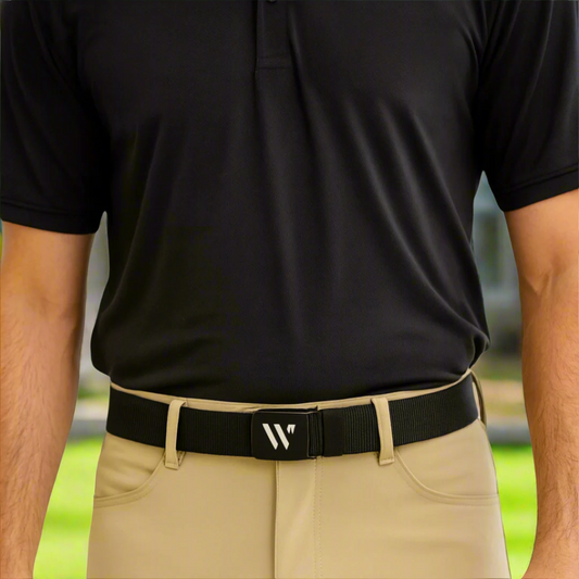 Person wearing a black polo shirt and beige pants with a black belt featuring a logo.