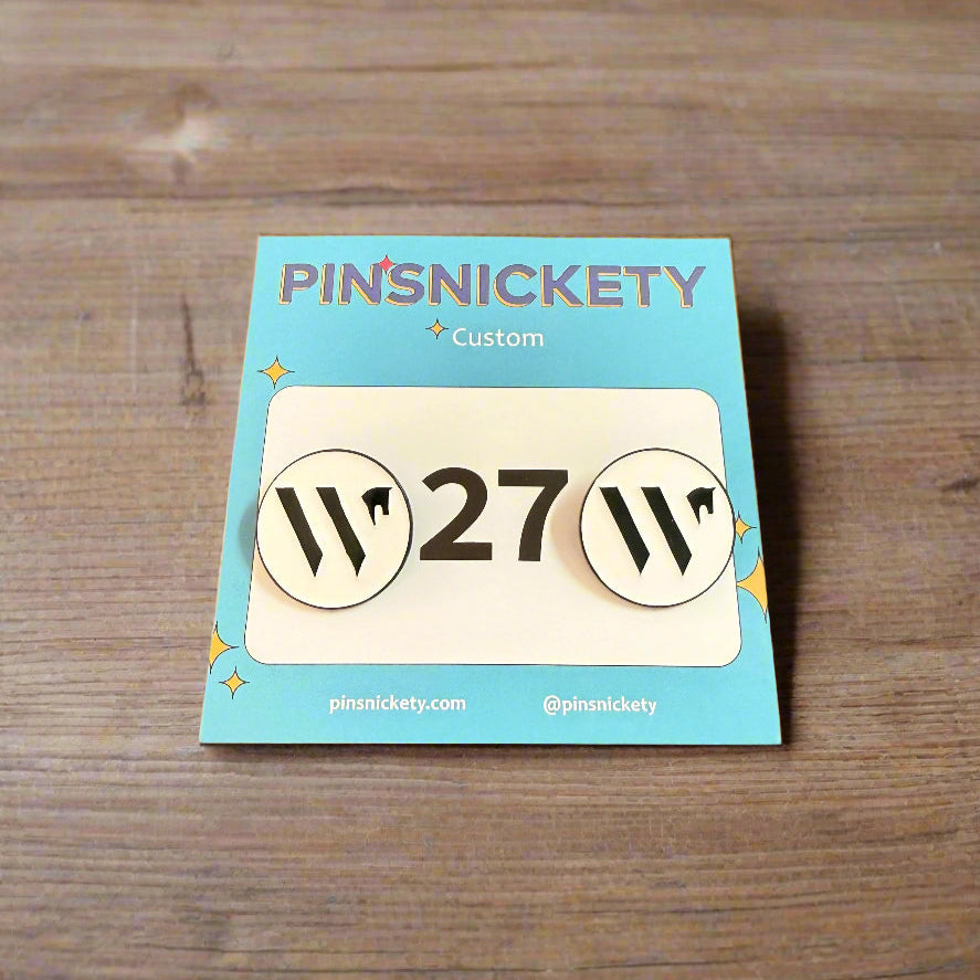Pins with Wellington International branding on a wooden surface