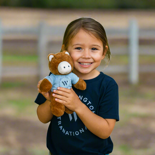 child holding wellington international horse plushie