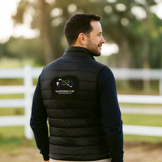 Man wearing a black puffer vest with jumping Nations Cup logo outdoors