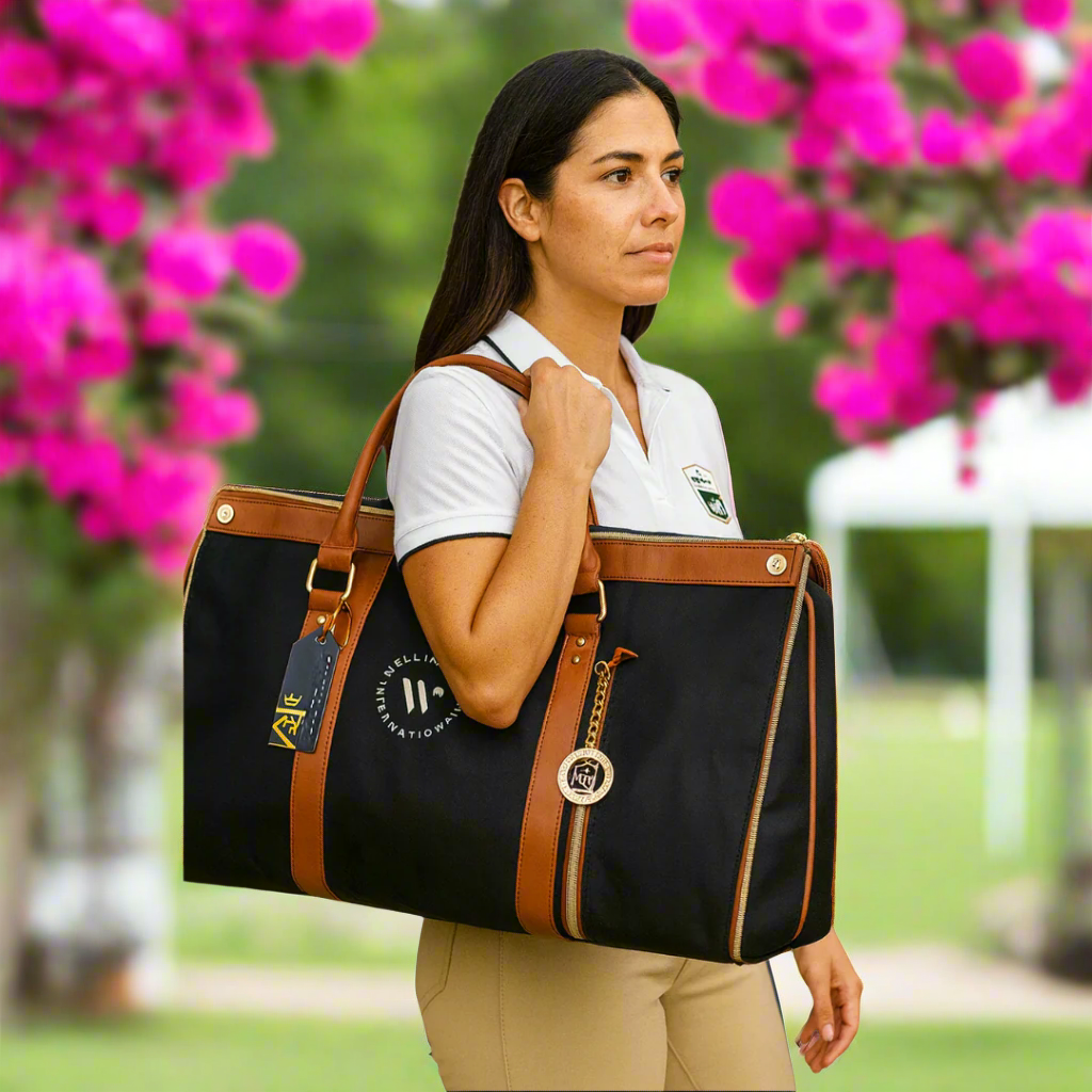 woman holding black garment bag with logo outside