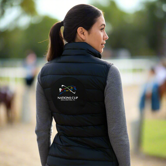 Person wearing a black puffer vest with jumper Nations Cup logo outside