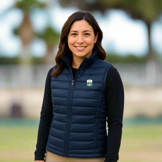 Woman wearing a navy blue puffer vest with a logo outside